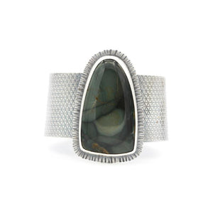 Wide sterling silver cuff with embossed small geometric design and large green and brown Larsonite gemstone