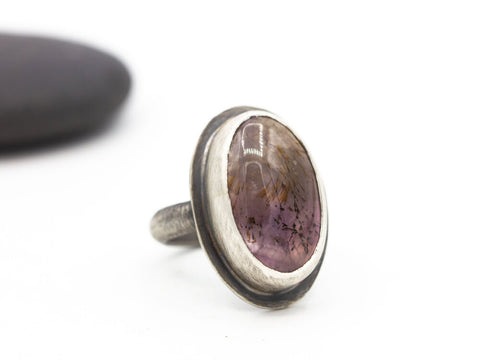 Transparent cacoxenite in amethyst oval cabochon set in sterling silver on a half-round sterling band. Size 6.5